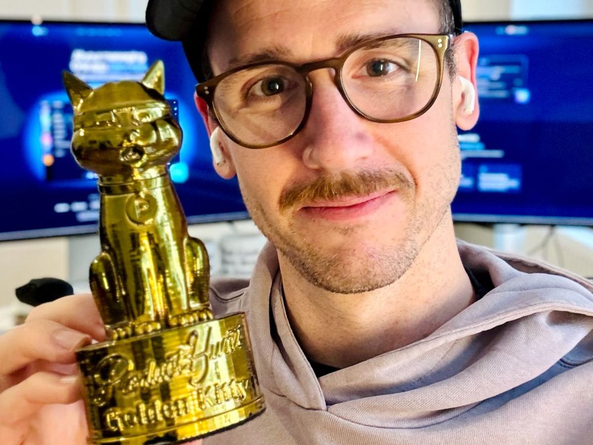 Someone holding a Golden Kitty trophy up to the camera
